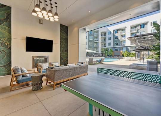 A modern living room with a pool table and a television.