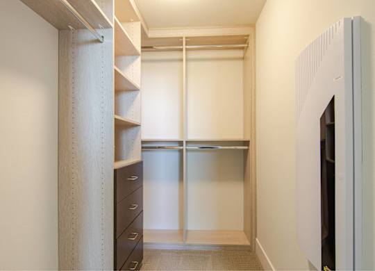 A white closet with a sliding door and a shelf.