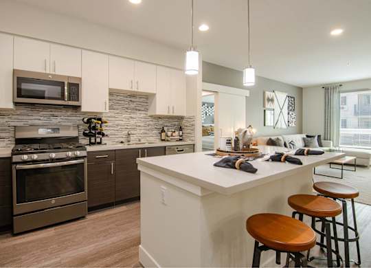 A modern kitchen with a white island and stainless steel appliances.