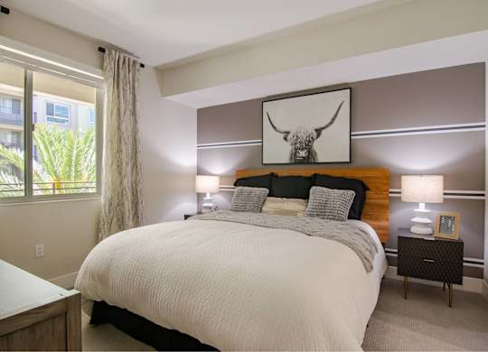 A bedroom with a large bed and a painting above it.