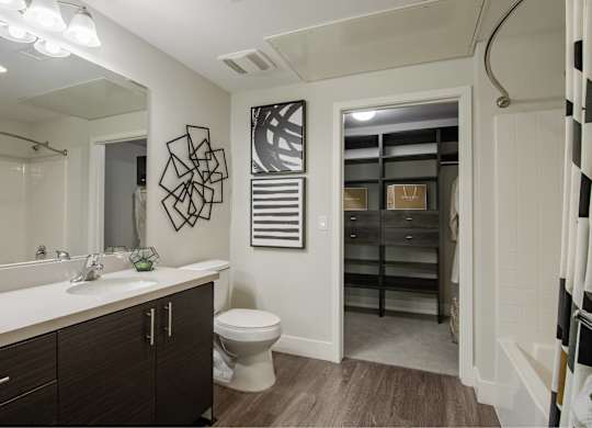 A bathroom with a toilet, sink, and a mirror.