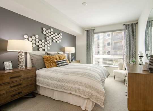 A bedroom with a large bed and a mirror on the wall.
