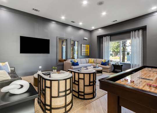A modern living room with a pool table and a television.