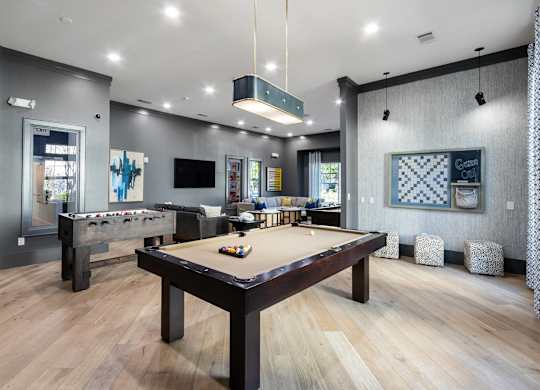 A room with a pool table and a TV.