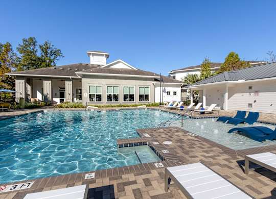 A large swimming pool with a building in the background.