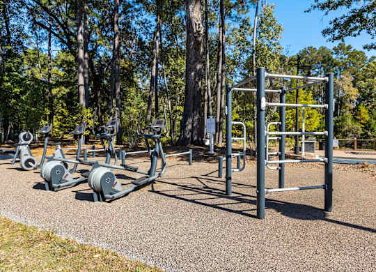 A park with a variety of outdoor exercise equipment.