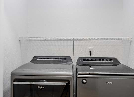 Two toaster ovens are sitting on a shelf.