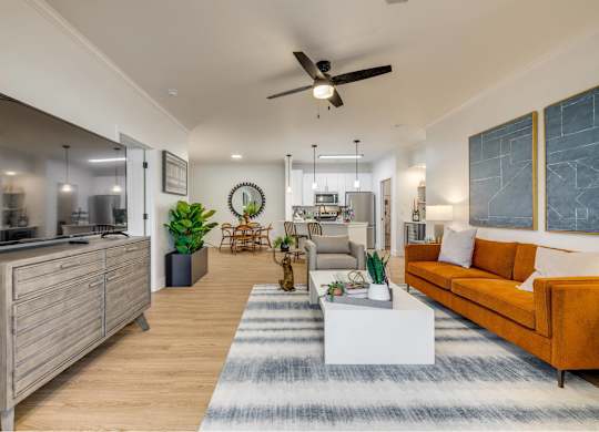 A modern living room with a kitchen area in the background.