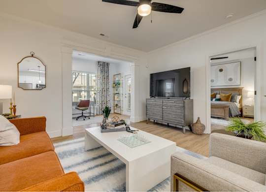 A living room with a white sofa and a white coffee table.
