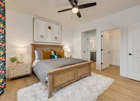 A bedroom with a bed, nightstand, and a ceiling fan.