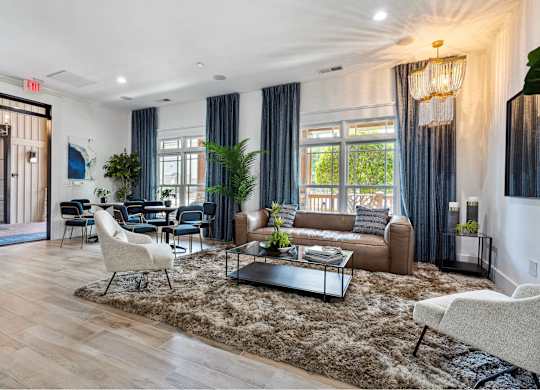 A living room with a brown sofa, a white chair, and a glass coffee table.