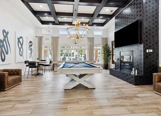 A living room with a pool table and a fireplace.