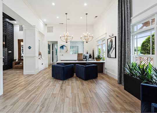 A spacious living room with wooden floors and a large window.