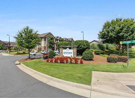 A street view of a residential area with a sign that reads
