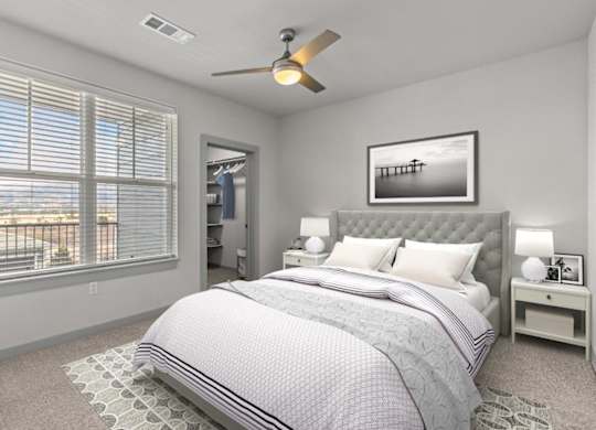 A bedroom with a large bed and a ceiling fan.