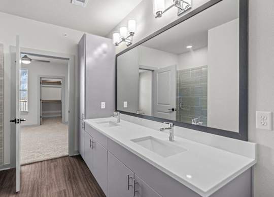A bathroom with a sink, mirror, and a glass shower door.
