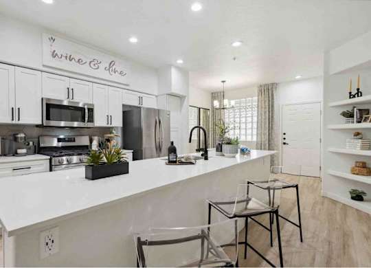 A modern kitchen with a white countertop and stainless steel appliances.