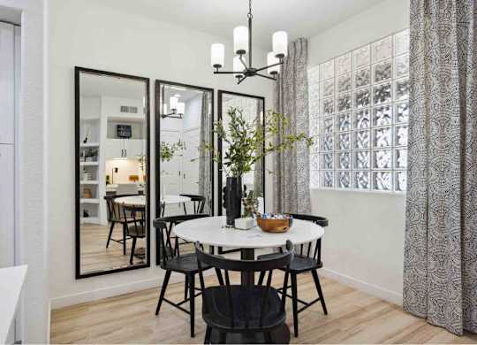 A dining room with a round table and chairs.