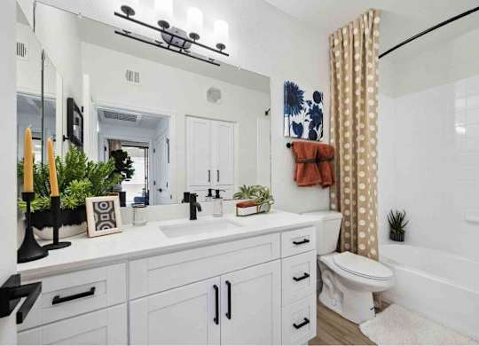 A white bathroom with a toilet, sink, and mirror.