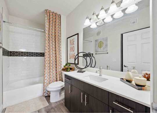 A bathroom with a white tub and a white toilet.