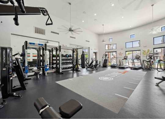 A spacious gym with a variety of equipment including treadmills, weights, and exercise machines.