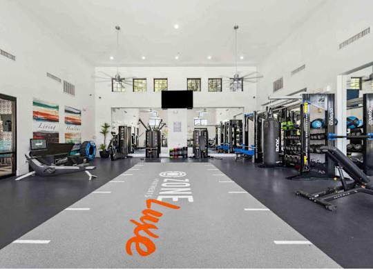A gym with a variety of equipment and a large mirror on the wall.