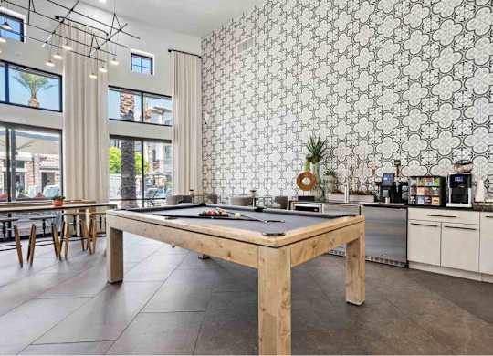 A kitchen with a wooden table and a patterned wallpaper.