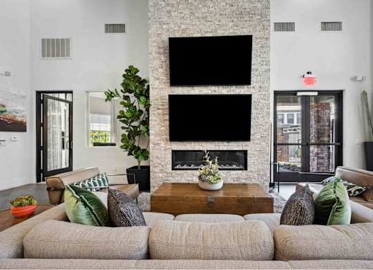 A living room with a grey sofa and a fireplace.
