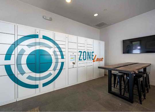 A room with a table and chairs and a wall with a logo and the word ZONE on it.