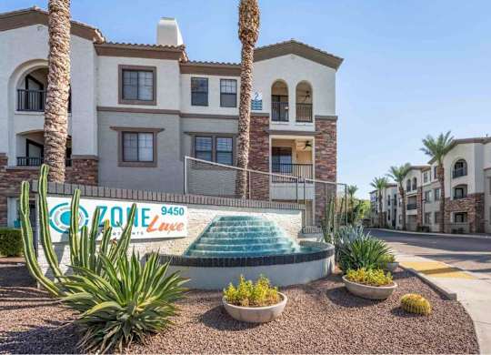 A building with a pool in front of it and a sign that says