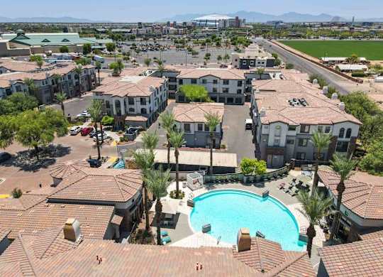 A large swimming pool is surrounded by apartment buildings.