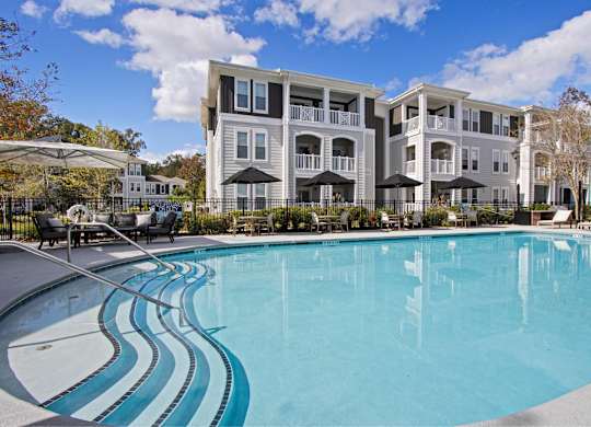 a large swimming pool with an apartment building in the background