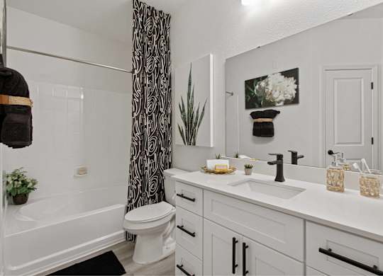 an open bathroom with a shower and a sink and a toilet