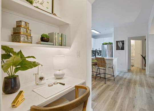 a home office with a desk and a living room with a kitchen