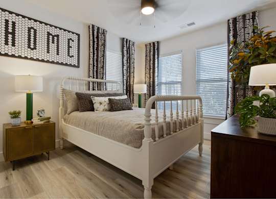 a bedroom with a bed and a dresser and windows