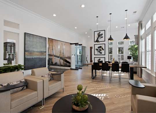 a living room and dining room with white walls and wood floors
