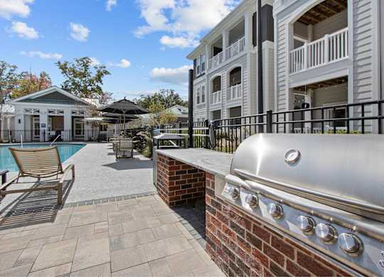 a barbecue grill on a brick wall next to a pool