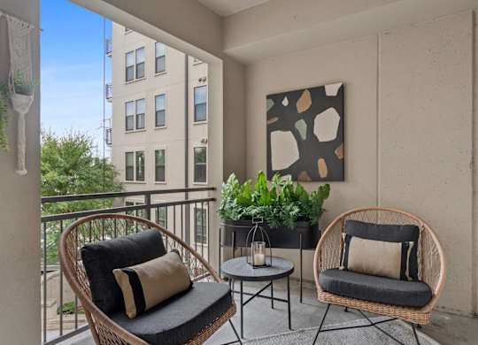 A balcony with two chairs and a table.