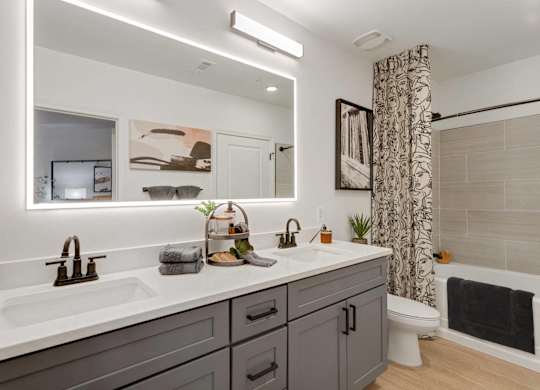 A bathroom with a white countertop and a grey cabinet.