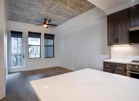 A kitchen with a white countertop and wooden cabinets.
