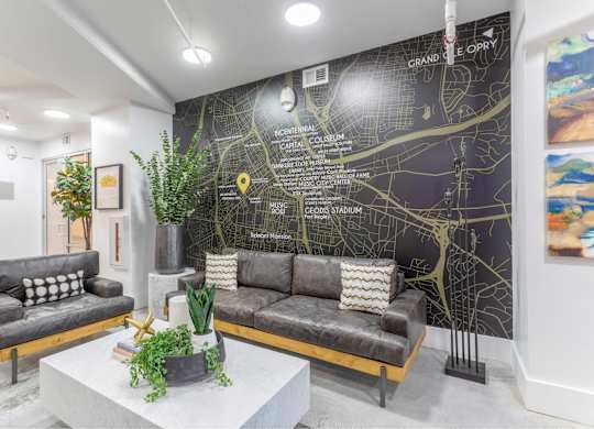 A living room with a grey sofa and a map on the wall.