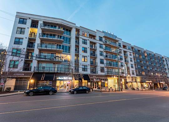 A large apartment building with cars parked in front.