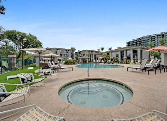 a pool with lounge chairs and umbrellas