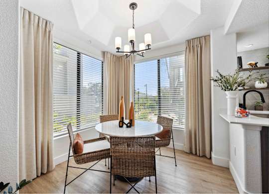 a dining room with large windows and a chandelier
