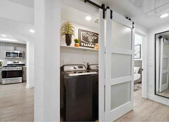 a sliding barn door separates the Washer/Dryer from the living room