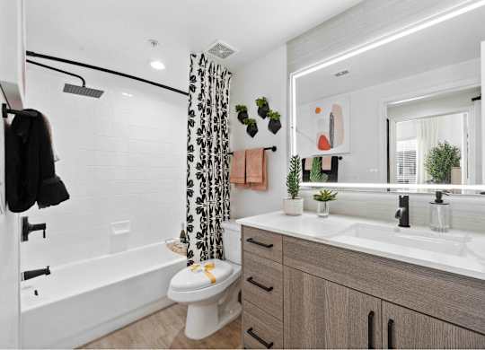 a bathroom with a white toilet next to a bathtub with a shower curtain
