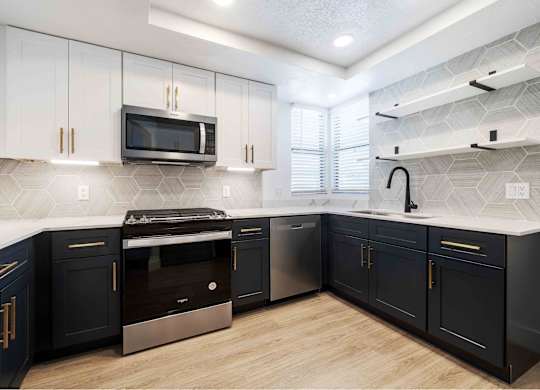 a kitchen with blue and white cabinets and stainless steel appliances