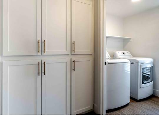 a laundry room with white cabinets and washer and dryer