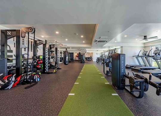 a spacious fitness center with cardio machines and weights