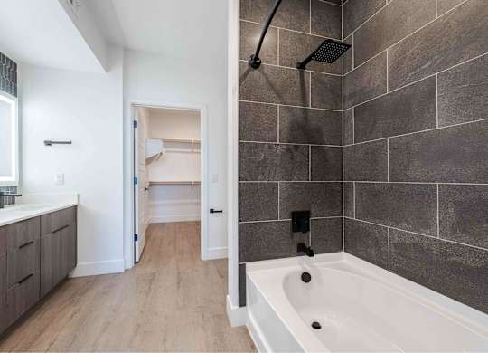 a bathroom with a tub and a shower and a sink